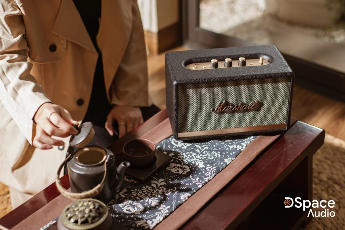 Marshall Acton 2 giữ nguyên nét đẹp cổ điển với dáng hộp vuông vắn, nhỏ gọn (260 x 160 x 150 mm, nặng 2,85kg). Thiết kế này giúp loa dễ dàng bố trí trên bàn làm việc, kệ TV, giá sách, tủ đầu giường hay bất cứ vị trí nào trong nhà mà không chiếm nhiều diện tích. Vỏ loa được làm từ gỗ MDF bọc da cao cấp, vừa tăng độ bền vừa mang lại cảm giác sang trọng, chắc chắn khi chạm vào.